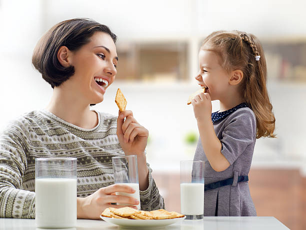 cibo salutare - little girls small eating breakfast foto e immagini stock