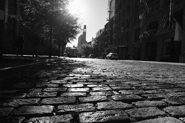 Close up view of cobblestones on a New York City street as the sun rises in the morning