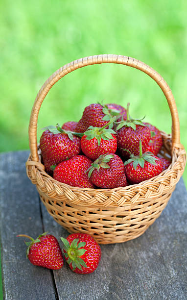 istock basket with strawberries on wooden surface 494432669