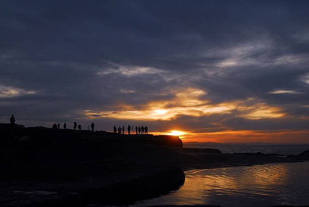 Pôr do sol sobre a praia e fotógrafos - fotografia de stock