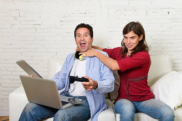 woman strangling technology freak boyfriend for being internet addict young attractive frustrated woman strangling technology freak husband or boyfriend for being electronic devices and internet addiction concept woman strangles man stock pictures, royalty-free photos & images