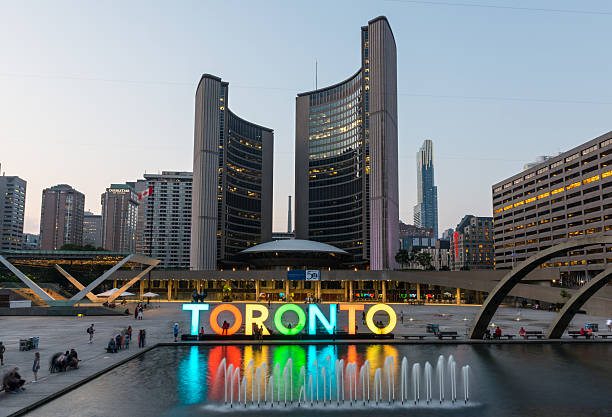 Nathan Phillips Square and City Hall on Toronto Toronto, Сanada - September 6, 2015: Night long exposure of the fountain in Nathan Phillips Square with the illuminated City Hall and the Freedom Arches in the background. toronto stock pictures, royalty-free photos & images