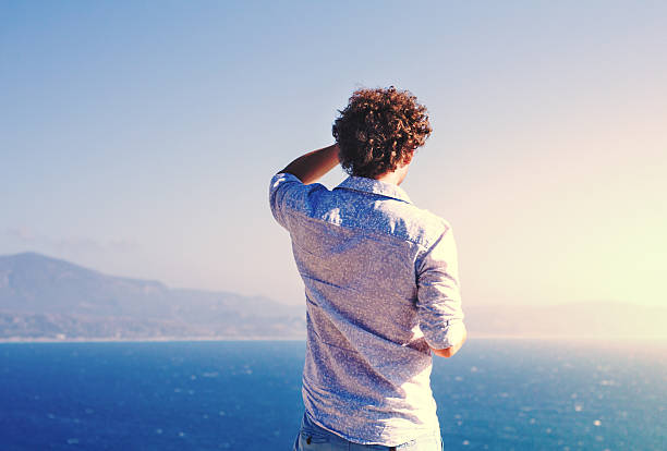 istock tourist looking into the distance on blue sea 494440228