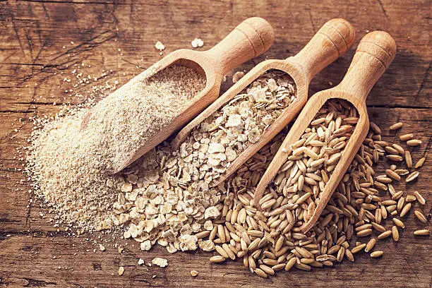 Oat flakes, seeds and bran in spoons