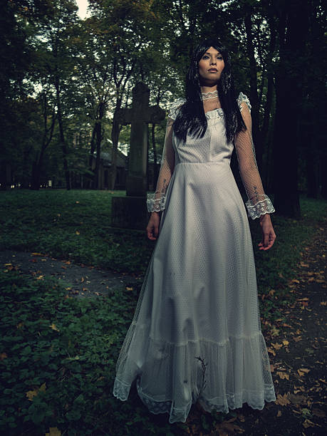 istock Witch from the cemetery, in front of cross 494441608