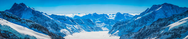 Sweeping super high resolution panoramic vista over the massive Aletsch Glacier as it slowly tumbles through the UNESCO World Heritage Site high in the Bernese Alps of Switzerland between the Gross Fiescherhorn (4049m) and the Aletschhorn (4193m) towards Valais. ProPhoto RGB profile for maximum color fidelity and gamut.