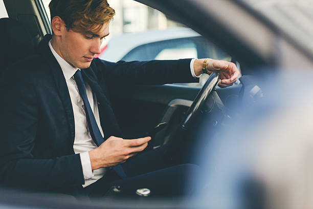 istock Business man working on his mobile phone in car 494443492