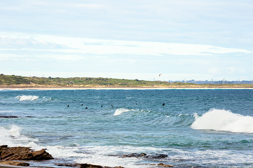 Group of surfers surfing the waves in Bate Bay Pacific ocean, Cronulla Australia, full frame horizontal composition with copy space