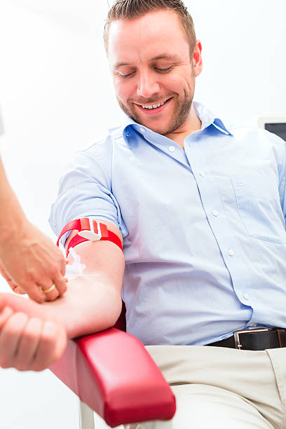 Doctor taking blood sample Female doctor or nurse taking blood sample from patient medicate stock pictures, royalty-free photos & images