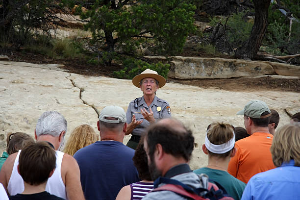 Mesa Verde Tour Group Mesa Verde National Park, CO - July 26, 2008: A park ranger speaks to a tour group prior to descending to the ancient Anasazi ruins of Cliff Palace in Mesa Verde National Park.  park ranger stock pictures, royalty-free photos & images
