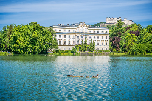 Famous Schloss Leopoldskron with Hohensalzburg Fortress in the background on a sunny day with blue sky in Salzburg, Austria