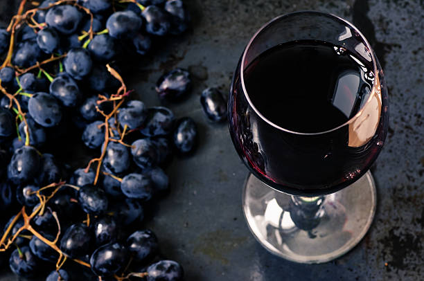 istock Wineglass of red wine with grapes 494465082