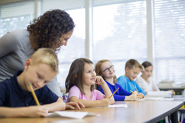 istock Young ethnic teacher works with her elementary school 494465230
