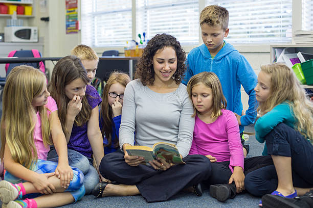 istock Young ethnic teacher reads to her elementary school 494465262
