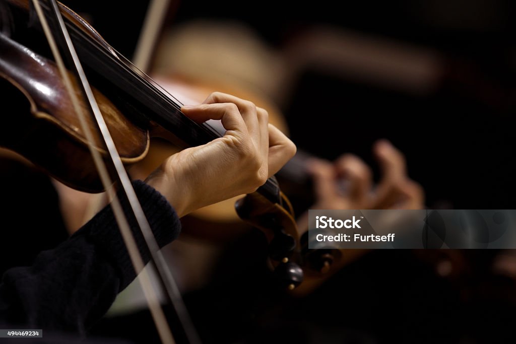 The girl's hand on the strings of a violin The girl's hand on the strings of a violin in dark colors Violin Stock Photo