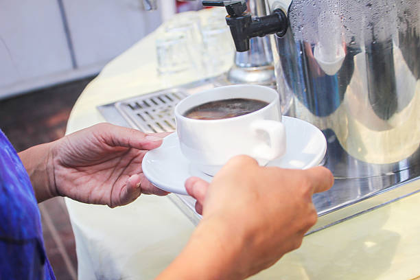 Adult woman preparing coffee for breakfast. Outdoor restaurant.