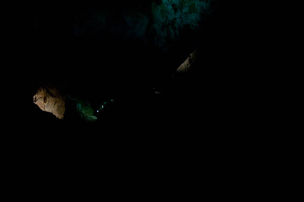 istock green spotlight in dark black cave 494470134