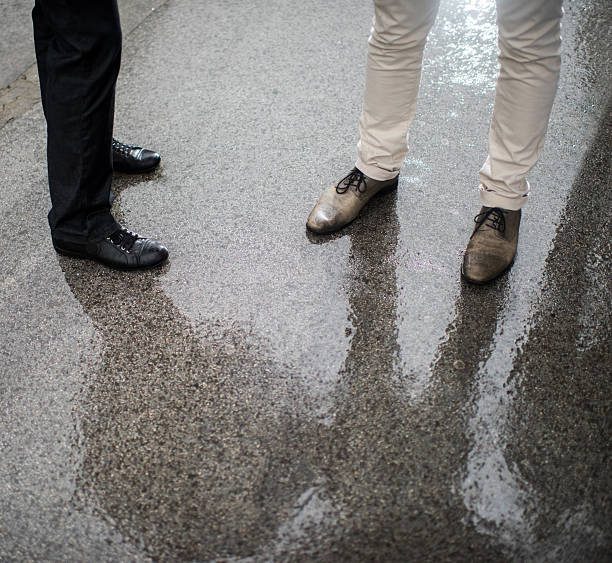 istock Unrecognizable businessmen legs on a wet pavement. 494475262