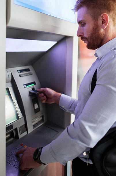 istock Young redhead businessman withdrawing money from ATM machine. 494476102