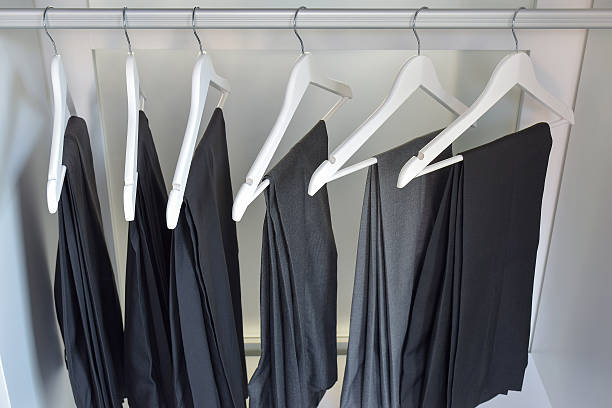 istock row of gray and black pants hangs in wardrobe 494476208