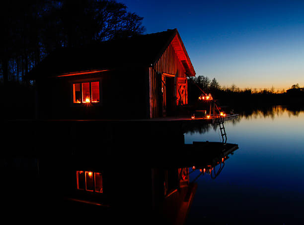 The house is reflected in the water. Night landscape with the stormy sky