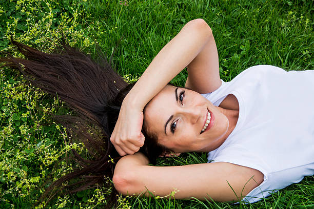 istock Young woman lying on a grass and smiling 494481053