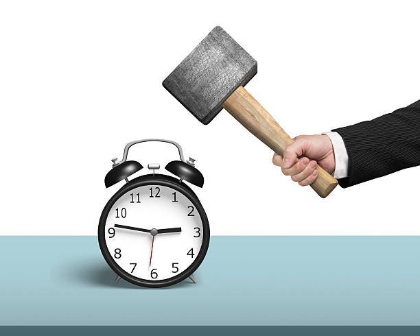 Hitting alarm clock on table Hitting alarm clock on table with white background smash alarm clock stock pictures, royalty-free photos & images