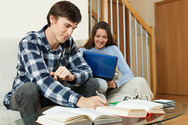 istock Student couple with books and laptop preparing for exams 494482911
