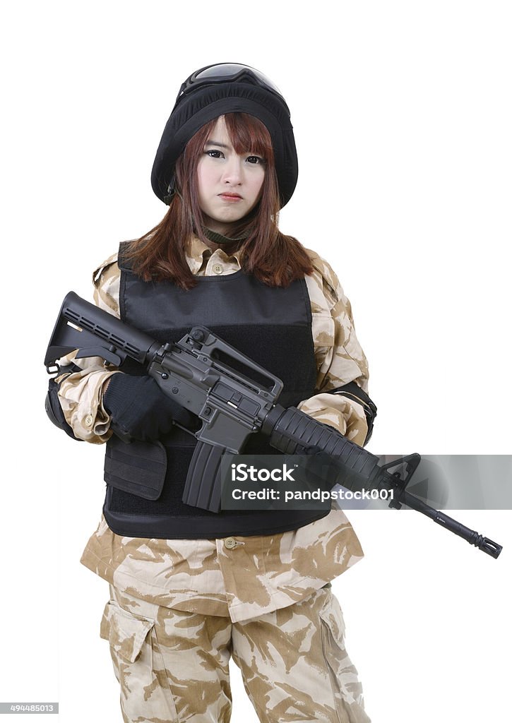 Female soldier in battle uniform. Young female soldier in battle uniform holding rifle on white background. Adult Stock Photo