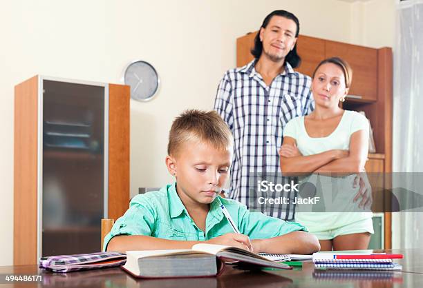 Parents Watching Their Son Doing Homework Stock Photo - Download Image Now - 10-11 Years, 30-39 Years, Adolescence