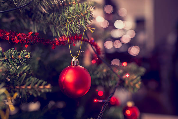 Closeup of red bauble hanging from Christmas tree stock photo