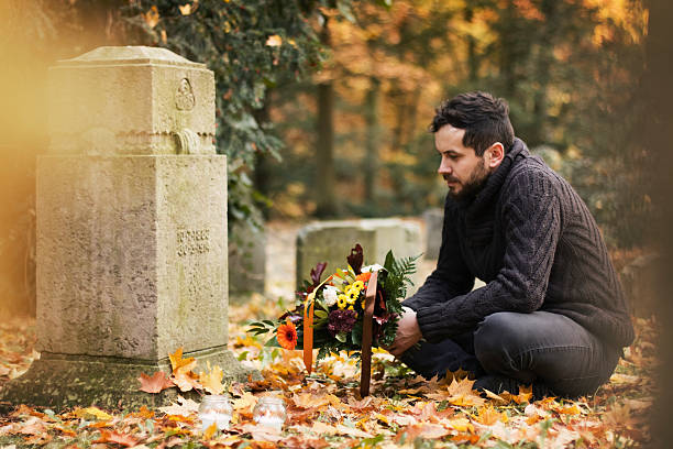 man in the cemetery - blommor grav bildbanksfoton och bilder