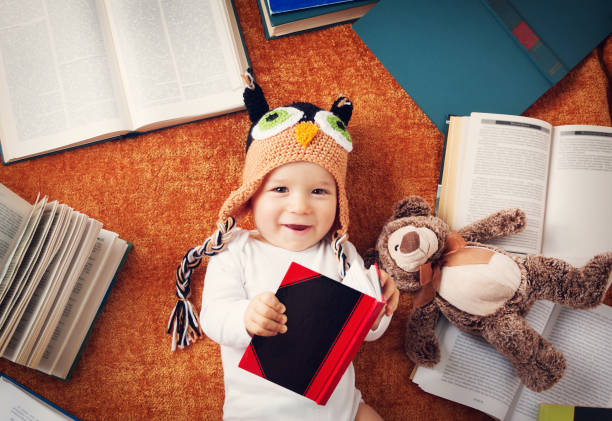 istock One year old baby reading books with teddy bear 494502388