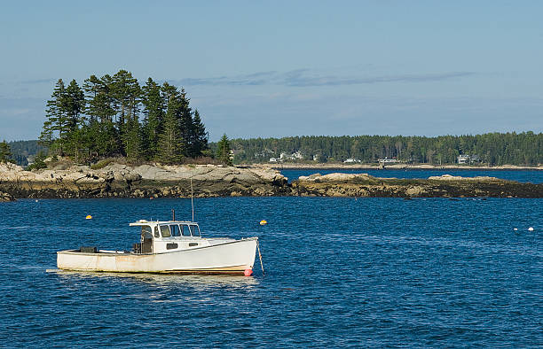 The sun sets behind a small island in Frenchman Bay near Acadia National Park and Bar Harbor, Maine, USA.