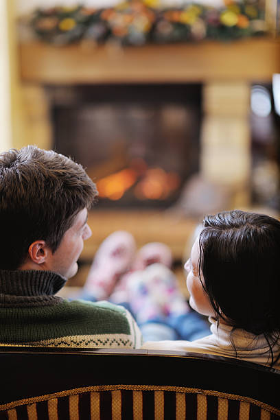 istock Young romantic couple sitting and relaxing in front of fireplace 494505901