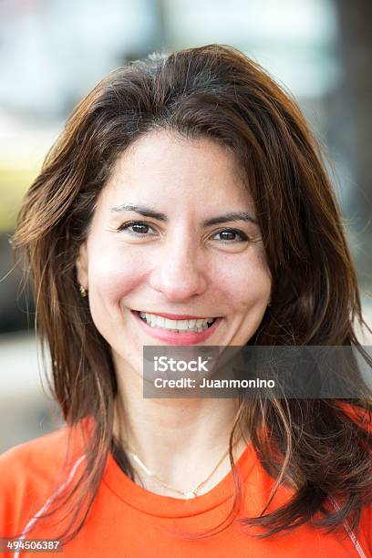 Smiling Woman In An Orange Shirt Looking At Camera Stock Photo - Download Image Now