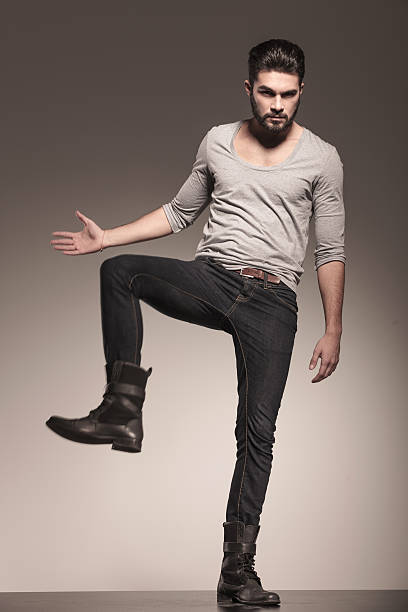 istock fashion young man with beard in a kicking pose 494508831