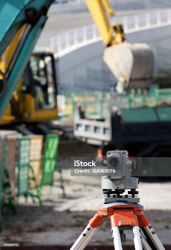 Dumpy level with excavator behind  The level instrument on the construction site 2015 Stock Photo