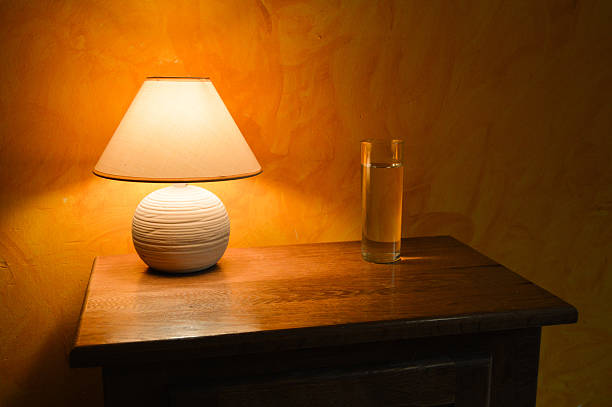 istock Bedside table with a light and a glass of water 494510212