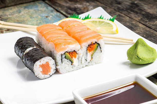 istock Seafood sushi rolls in white plate with chopsticks and spices 494512049