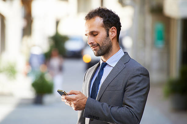 istock business man typing sms on mobile phone in street 494525457