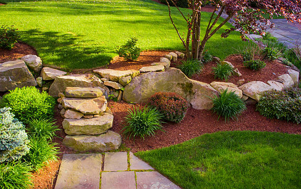 Well landscaped rock stairs and rock wall A backyard with a rock wall and rock stairs with a red tree on top. rock formations stock pictures, royalty-free photos & images