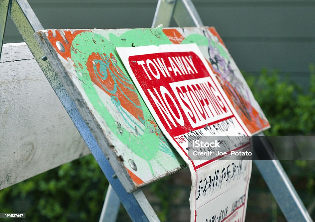 Tow Away Sign Tow Away Sign on paint-splattered construction barrier. Horizontal. Barricade Stock Photo