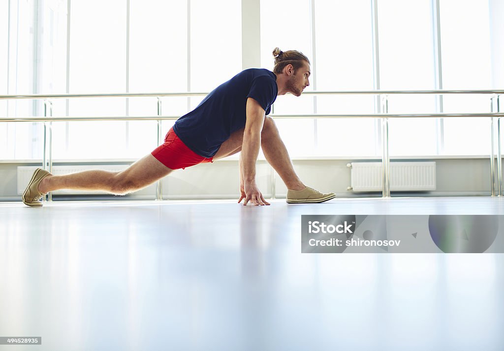 Exercise for stretching Portrait of young man doing physical exercise for stretching Active Lifestyle Stock Photo