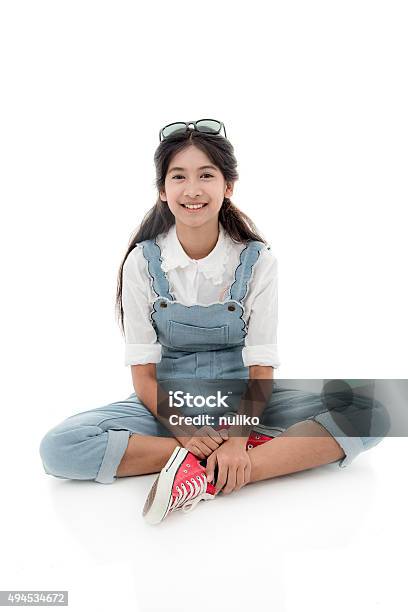 Asian Teenage Girl Smiling And Sitting On White Background Stock Photo - Download Image Now