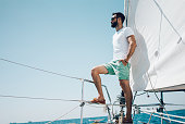 Low angle view of young bearded man standing on the