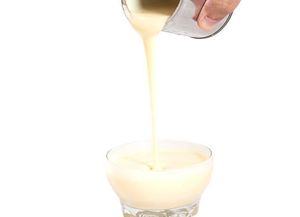 istock Man hand pouring condensed milk into a bowl isolated 494535718