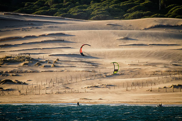 kiters sind reiten vor sand dunes - tarifa stock-fotos und bilder