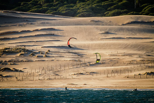 kiters sont équitation en face de dunes de sable - cadiz andalusia beach spain photos et images de collection