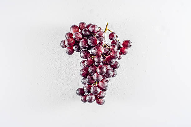 Close-up of grapes and water drops on bright background.